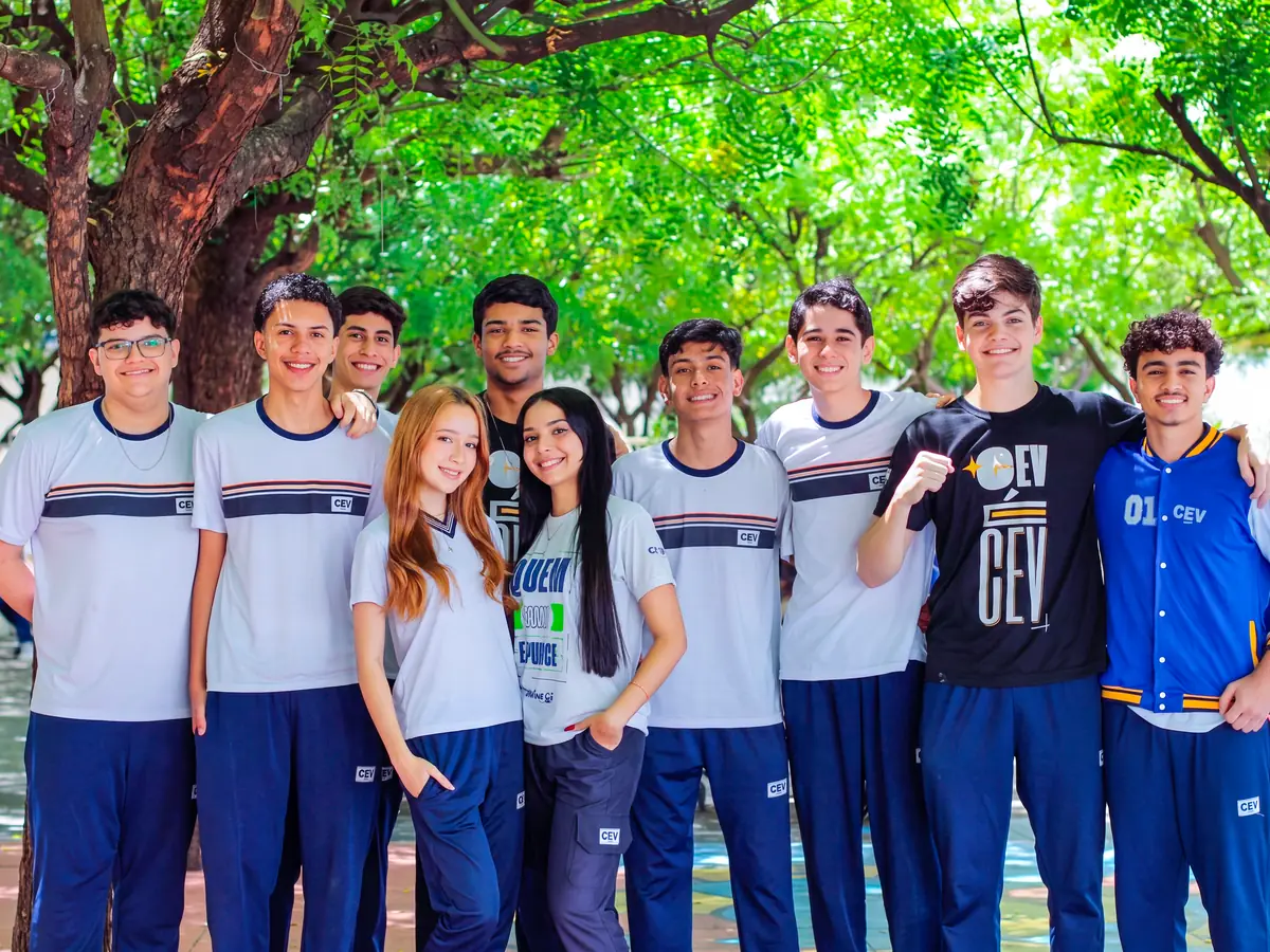 Estudantes uniformizados do CEV Colégio reunidos na área de convivência da escola