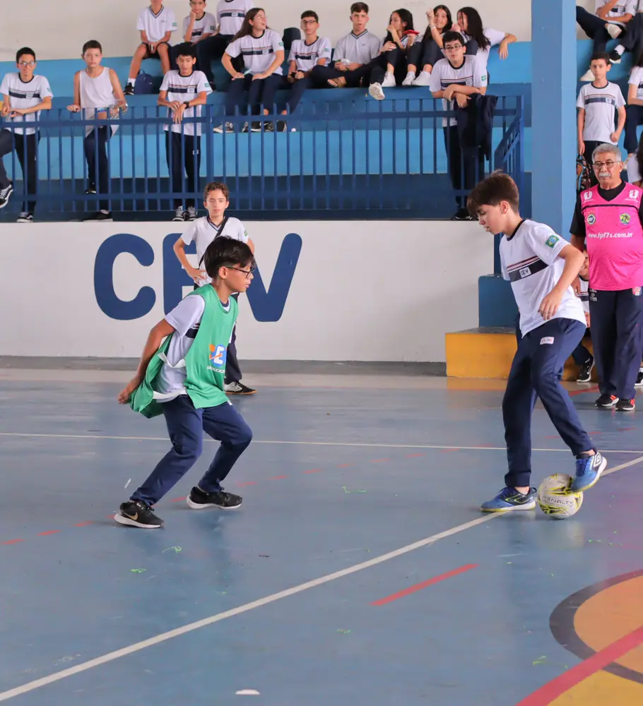 Estudantes jogando futsal na arena esportiva do CEV Colégio Kennedy