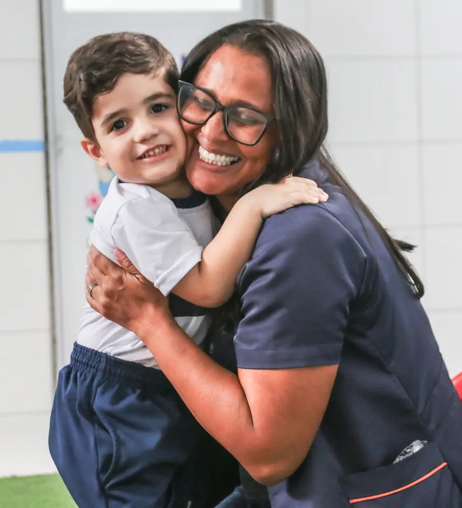 Educadora acolhendo uma criança no CEV Colégio Sul