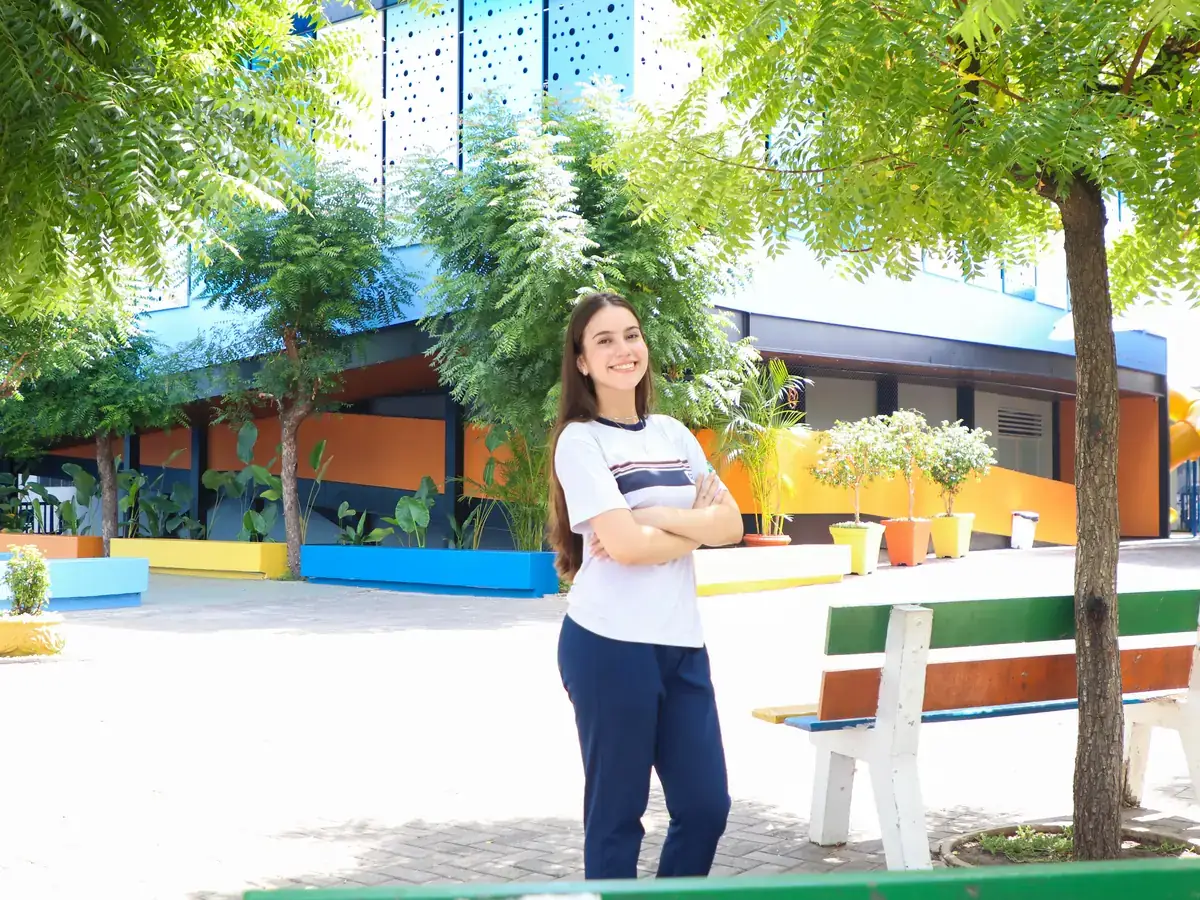 Estudante do CEV Colégio Kennedy na área de convivência arborizada
